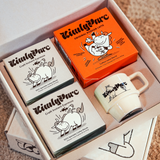 KintsyParc product set including boxes and a mug on a carpeted floor.